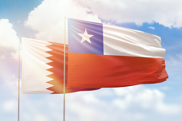 Sunny blue sky and flags of chile and qatar