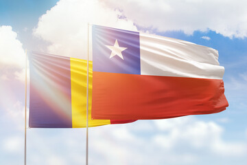 Sunny blue sky and flags of chile and romania