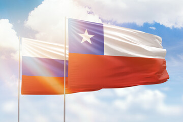 Sunny blue sky and flags of chile and russia