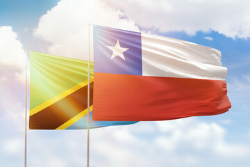 Sunny blue sky and flags of chile and tanzania