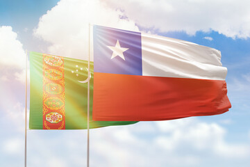 Sunny blue sky and flags of chile and turkmenistan