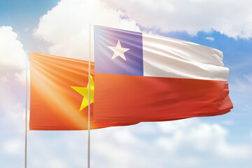 Sunny blue sky and flags of chile and vietnam