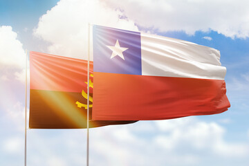 Sunny blue sky and flags of chile and angola