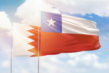 Sunny blue sky and flags of chile and bahrain
