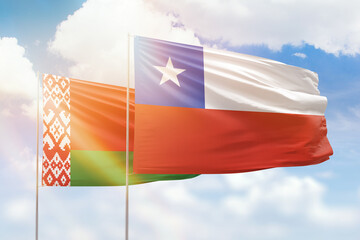 Sunny blue sky and flags of chile and belarus