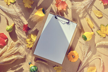 Autumn mockup, white paper on paper pad. Natural Fall leaves, wheat ears, small pumpkins, dry...