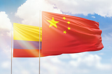 Sunny blue sky and flags of china and colombia