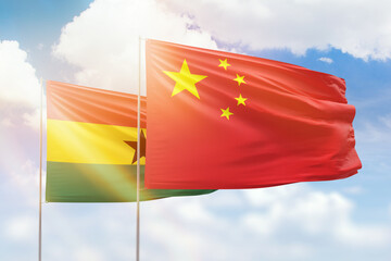 Sunny blue sky and flags of china and ghana