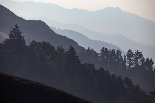 Hazy sunshine creates distinct layers in the landscape of Big Sur, Central California, USA