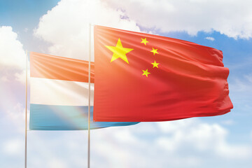 Sunny blue sky and flags of china and luxembourg