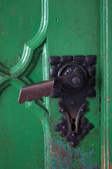 detai door handles in a wooden green historic door