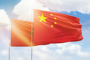 Sunny blue sky and flags of china and morocco