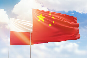 Sunny blue sky and flags of china and poland