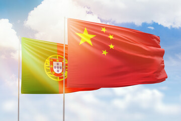 Sunny blue sky and flags of china and portugal