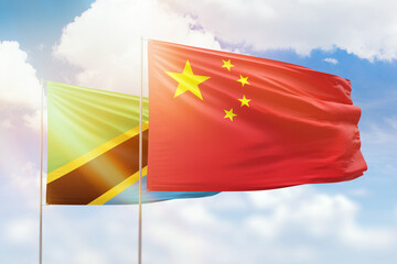 Sunny blue sky and flags of china and tanzania