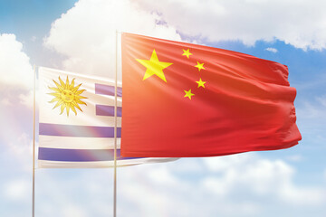 Sunny blue sky and flags of china and uruguay
