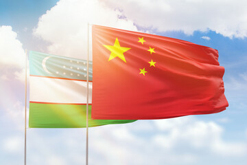Sunny blue sky and flags of china and uzbekistan