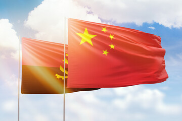 Sunny blue sky and flags of china and angola - obrazy, fototapety, plakaty