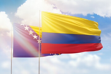 Sunny blue sky and flags of colombia and bosnia