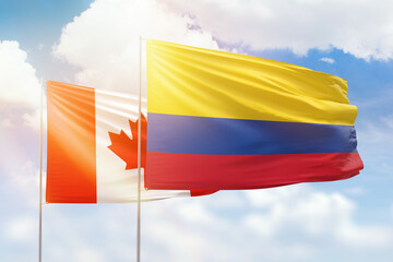 Sunny blue sky and flags of colombia and canada