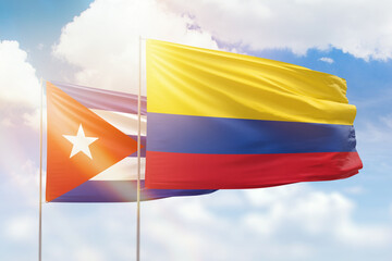 Sunny blue sky and flags of colombia and cuba