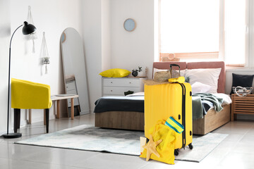 Packed suitcase with beach accessories in hotel room. Travel concept