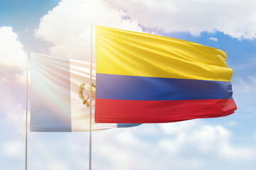 Sunny blue sky and flags of colombia and guatemala