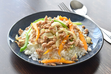 Fototapeta na wymiar Stir fried minced pork with bell pepper, garlic and onion topped on rice on a plate. 