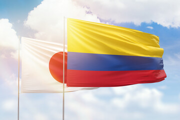 Sunny blue sky and flags of colombia and japan