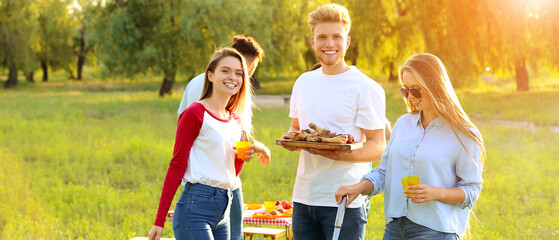 Friends cooking tasty food on barbecue grill outdoors
