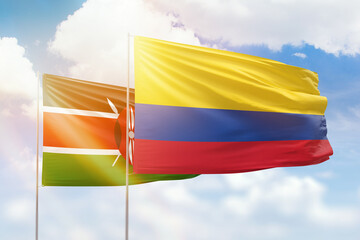 Sunny blue sky and flags of colombia and kenya