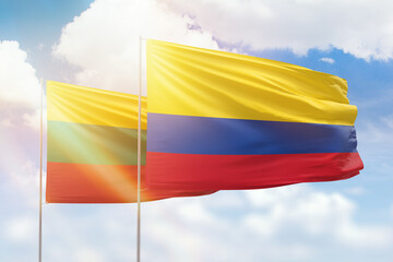 Sunny blue sky and flags of colombia and lithuania