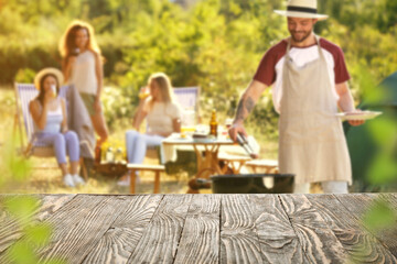 Empty wooden table at barbecue party outdoors - obrazy, fototapety, plakaty