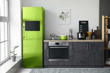 Interior of modern kitchen with green refrigerator