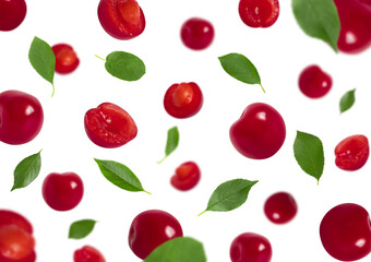 Set of falling cherries with green leaves isolated on a white background. Red berries flying in the air.