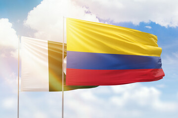Sunny blue sky and flags of colombia and pakistan