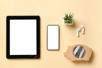 Tablet computer, mobile phone, earphones and money on color background