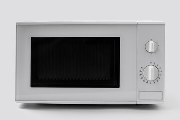 Fototapeta premium New modern microwave oven on light background