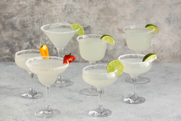 Glasses of tasty margarita cocktail on light background