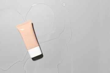 Makeup foundation in water on grey background