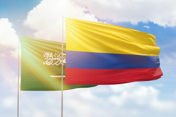 Sunny blue sky and flags of colombia and saudi arabia