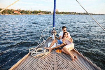 Happy young couple resting on yacht