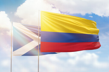 Sunny blue sky and flags of colombia and scotland