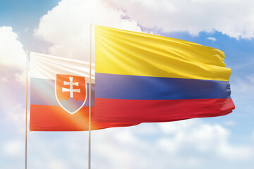 Sunny blue sky and flags of colombia and slovakia