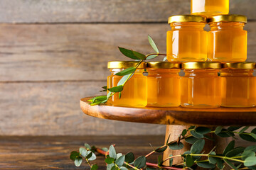 Jars with honey on wooden background