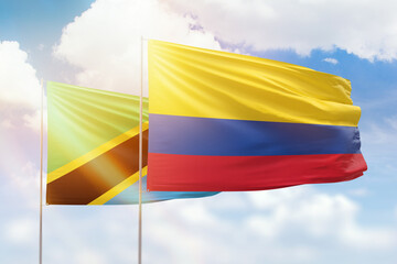 Sunny blue sky and flags of colombia and tanzania