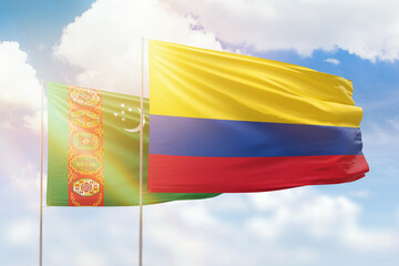 Sunny blue sky and flags of colombia and turkmenistan