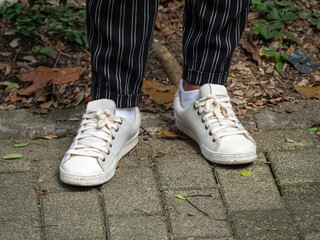 Woman Wearing Black Striped Trousers, White Socks and Off-White Shoes
