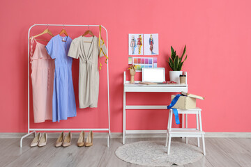 Obraz na płótnie Canvas Workplace of clothes stylist and rack with apparel near pink wall