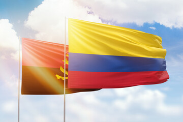 Sunny blue sky and flags of colombia and angola